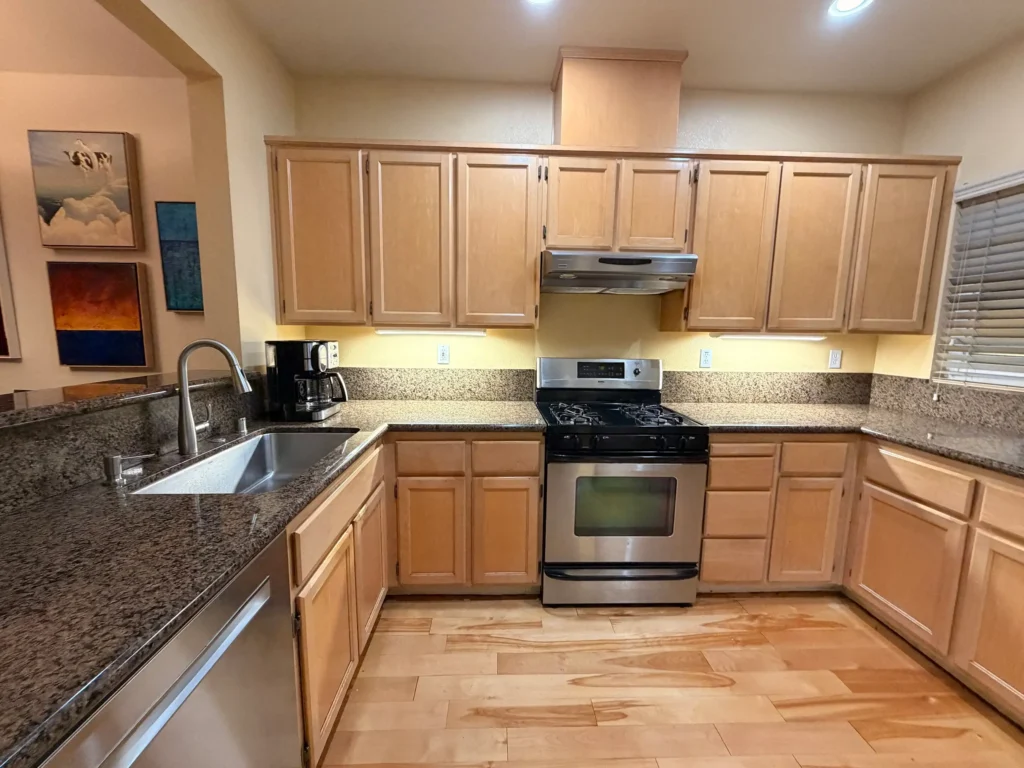 Brown kitchen before remodel — dark wood cabinets and brown granite countertops